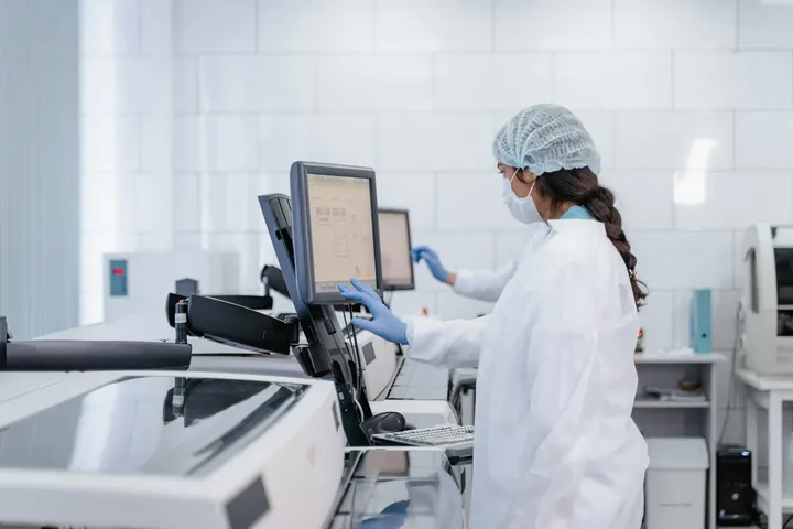 A laboratory scientist working with sample-processing equipment